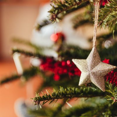 A selective focus shot of star ornament hanging on Christmas tree